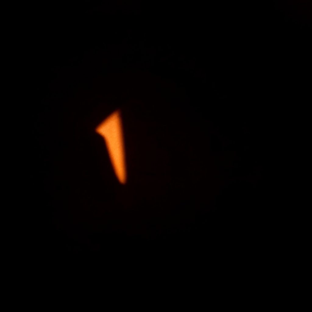 Dark, low-key photograph of a computer screen glowing in a dim room with abstract error code reflections on the surface, evoking cybersecurity and software troubleshooting.