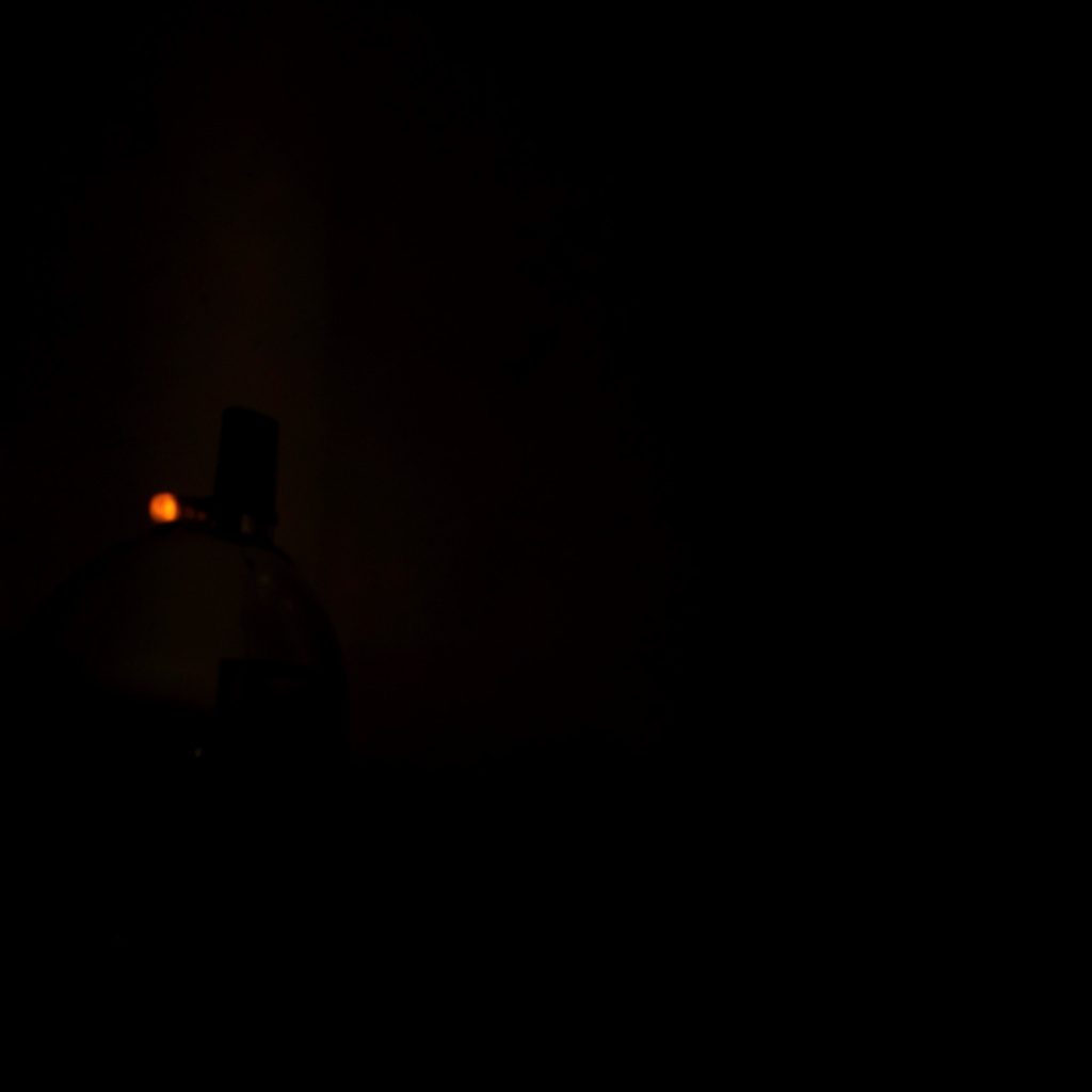 Dark low-light photograph of a glowing interface panel on a desktop monitor, evoking antivirus software features and protection.