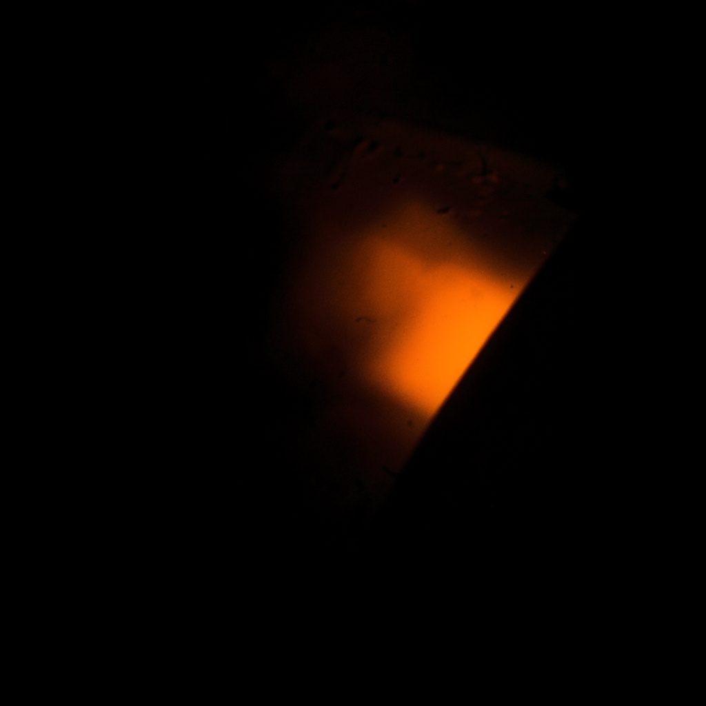 Dark, low-key close-up of a glowing security interface element, atmospheric and abstract with deep charcoal background.