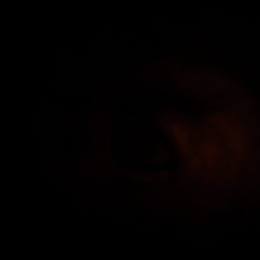 Dark, moody photograph of a security dashboard interface glowing softly on a screen in a dim room.